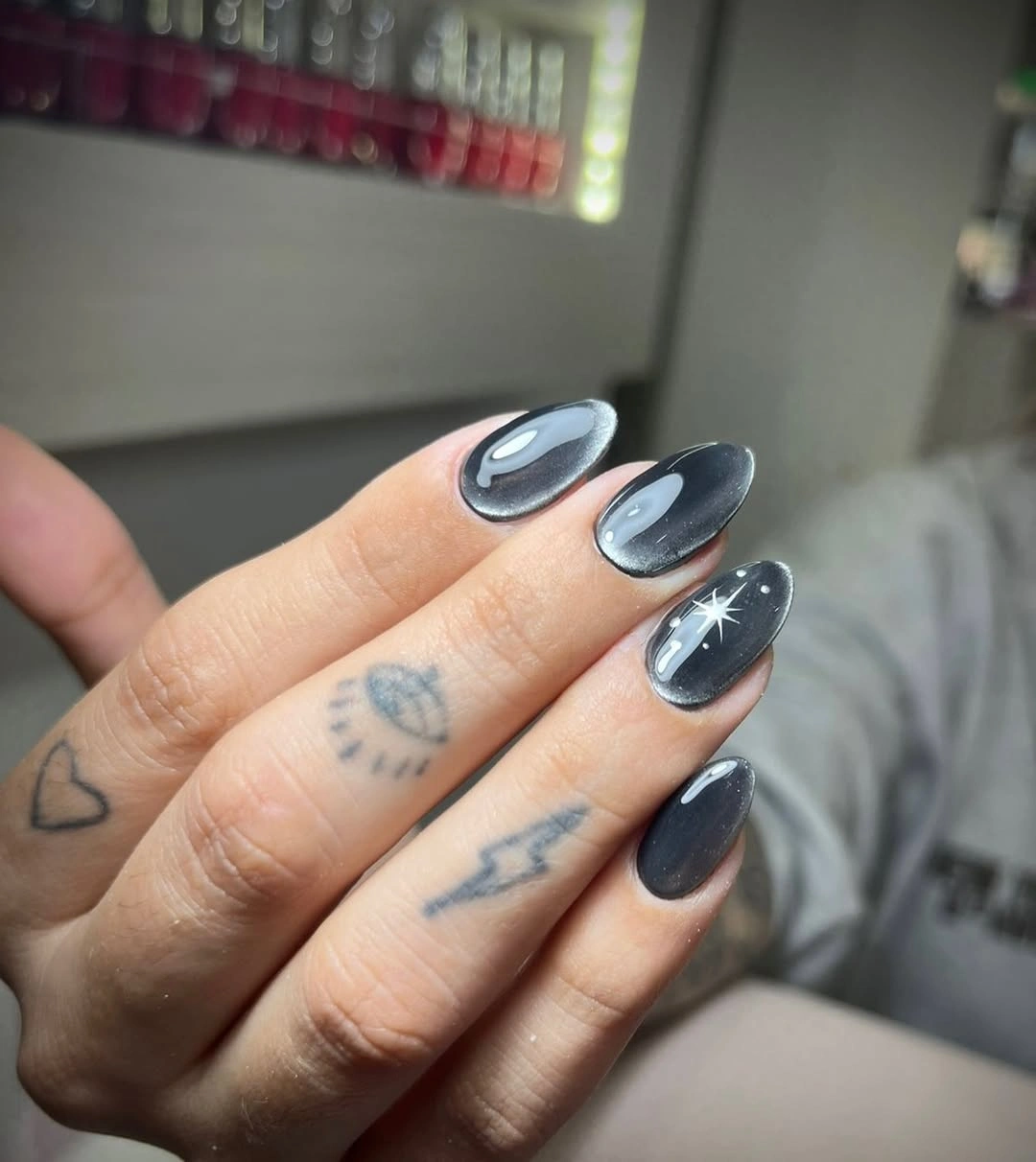 Almond blue-gray nails with luminous oval highlights and white starburst