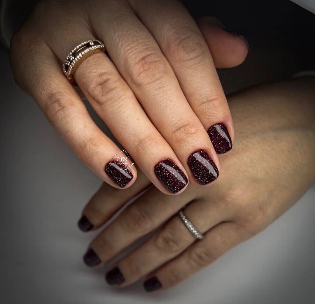 Short burgundy square nails with sparkle and pale diagonal bands