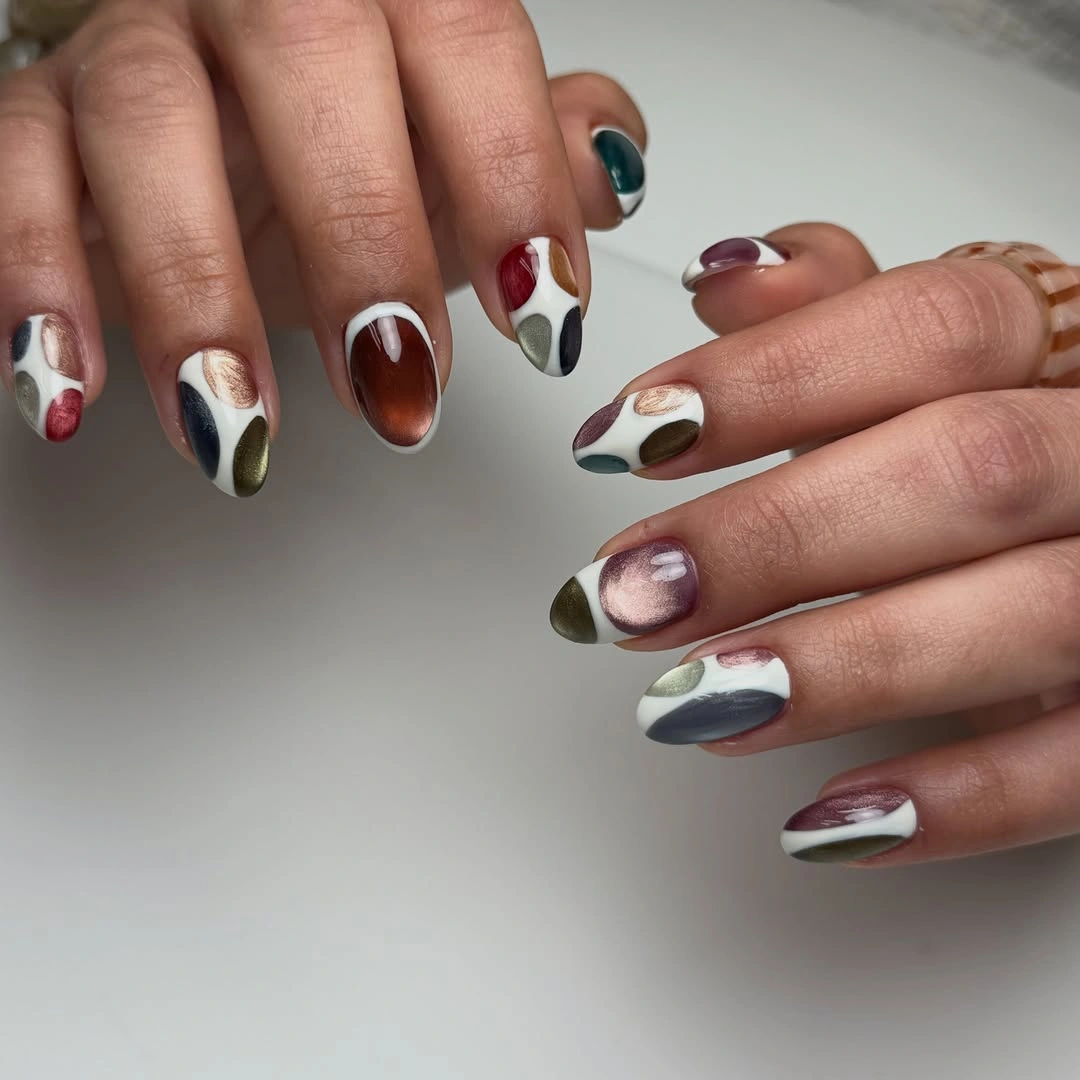 Rounded nails with cream, burgundy, olive, teal, and brown shapes