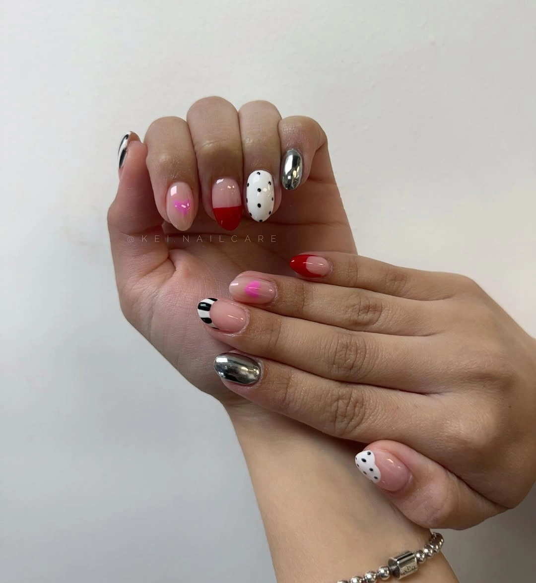 Short mixed nails with red, silver, pink, dots, and graphic tips