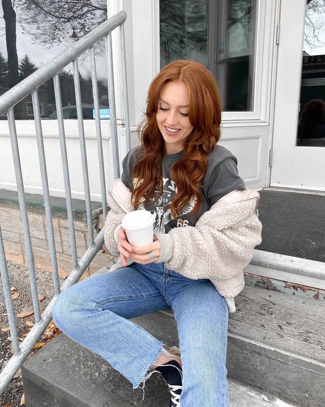 Pale textured jacket, graphic T-shirt, raw-hem jeans, black sneakers