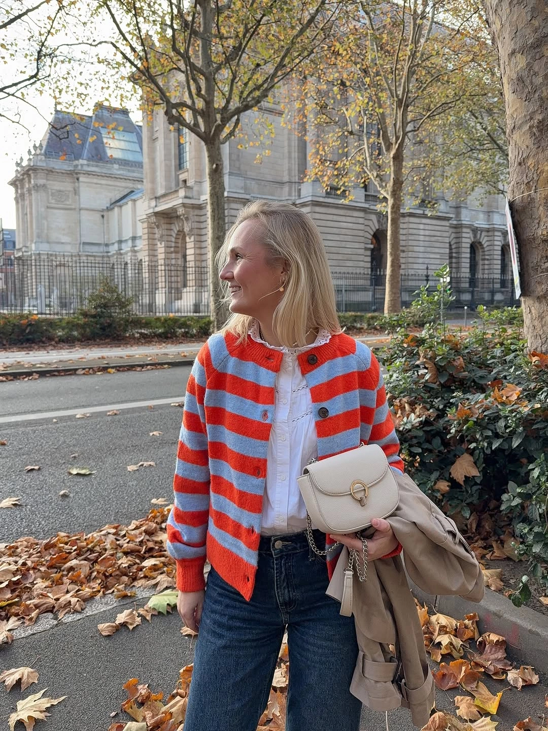 Red and blue striped cardigan, white top, jeans, light handbag