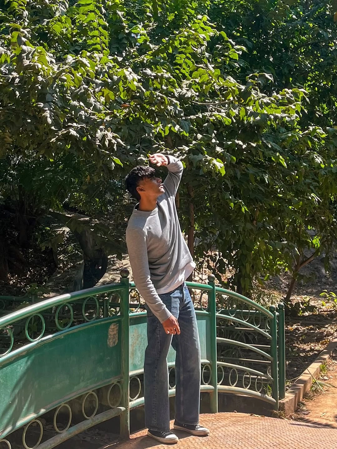 Light long-sleeve top with dark straight jeans and cap