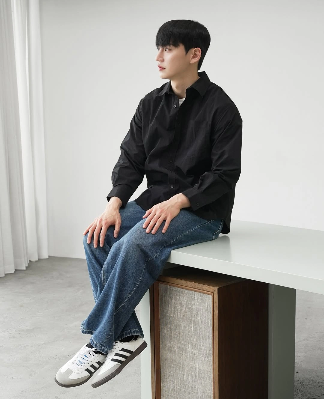 Black button shirt with relaxed blue jeans and white sneakers