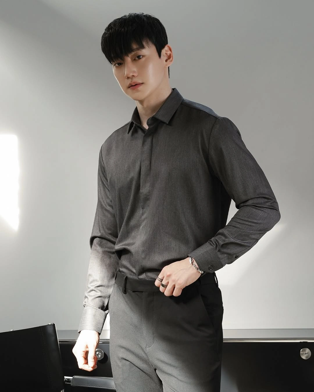 Black button shirt tucked into tailored black trousers