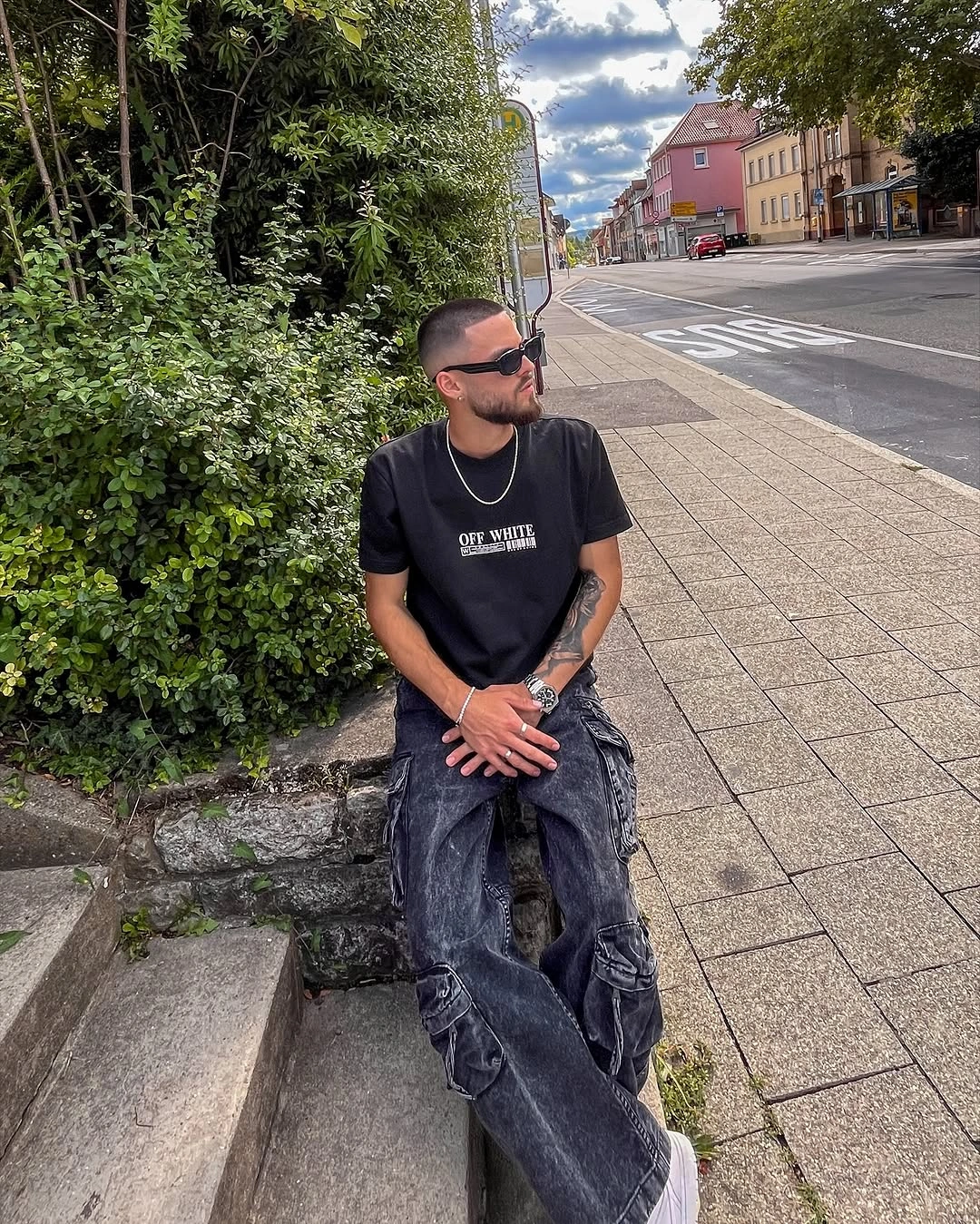 Black graphic T-shirt with loose dark denim and sunglasses