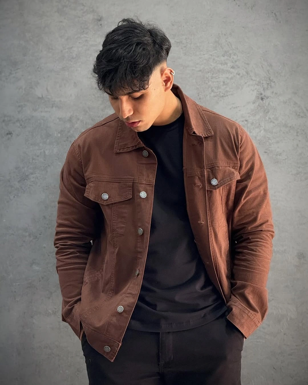 Brown overshirt layered over black shirt and trousers