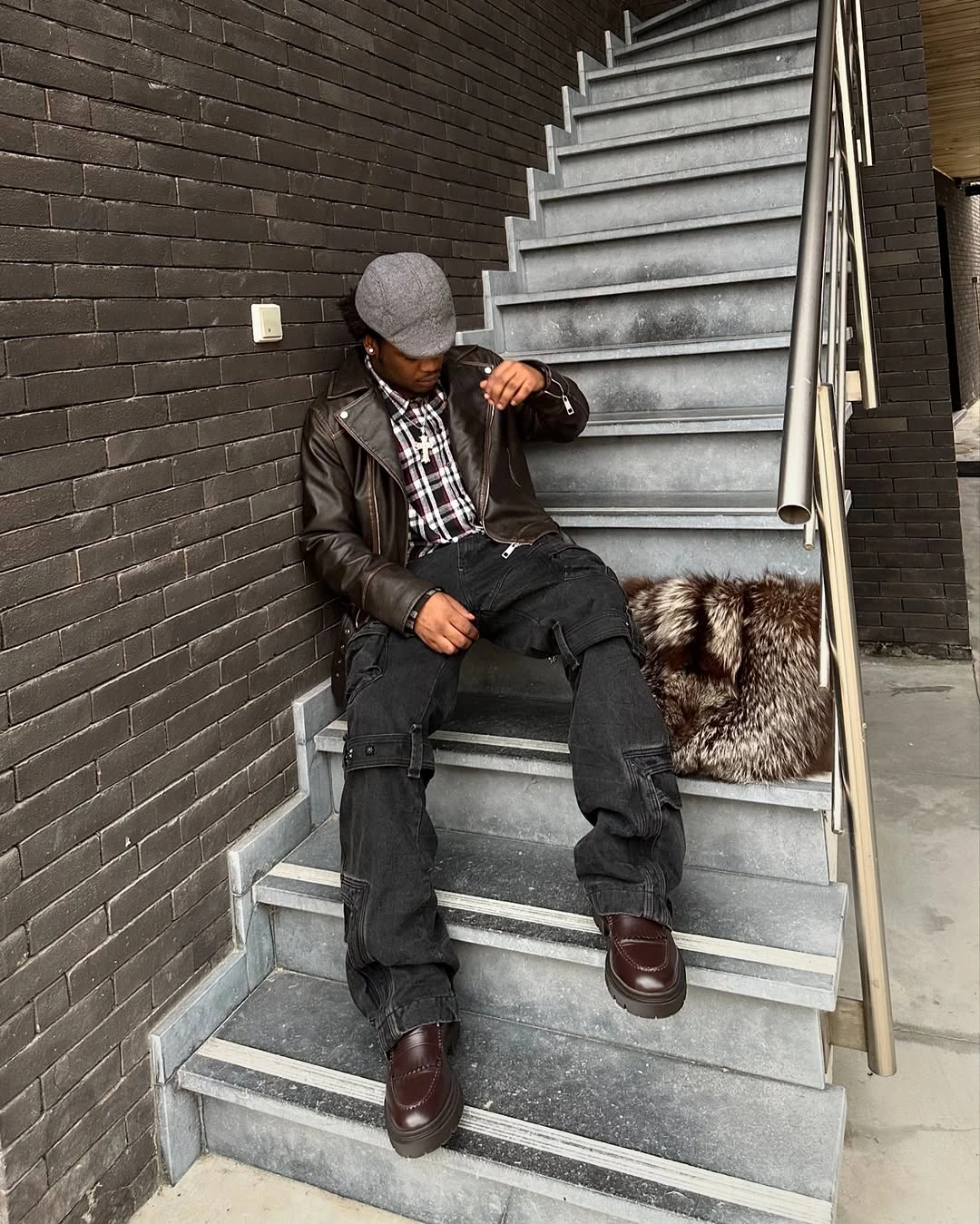 Dark textured jacket checked shirt flat cap and black trousers