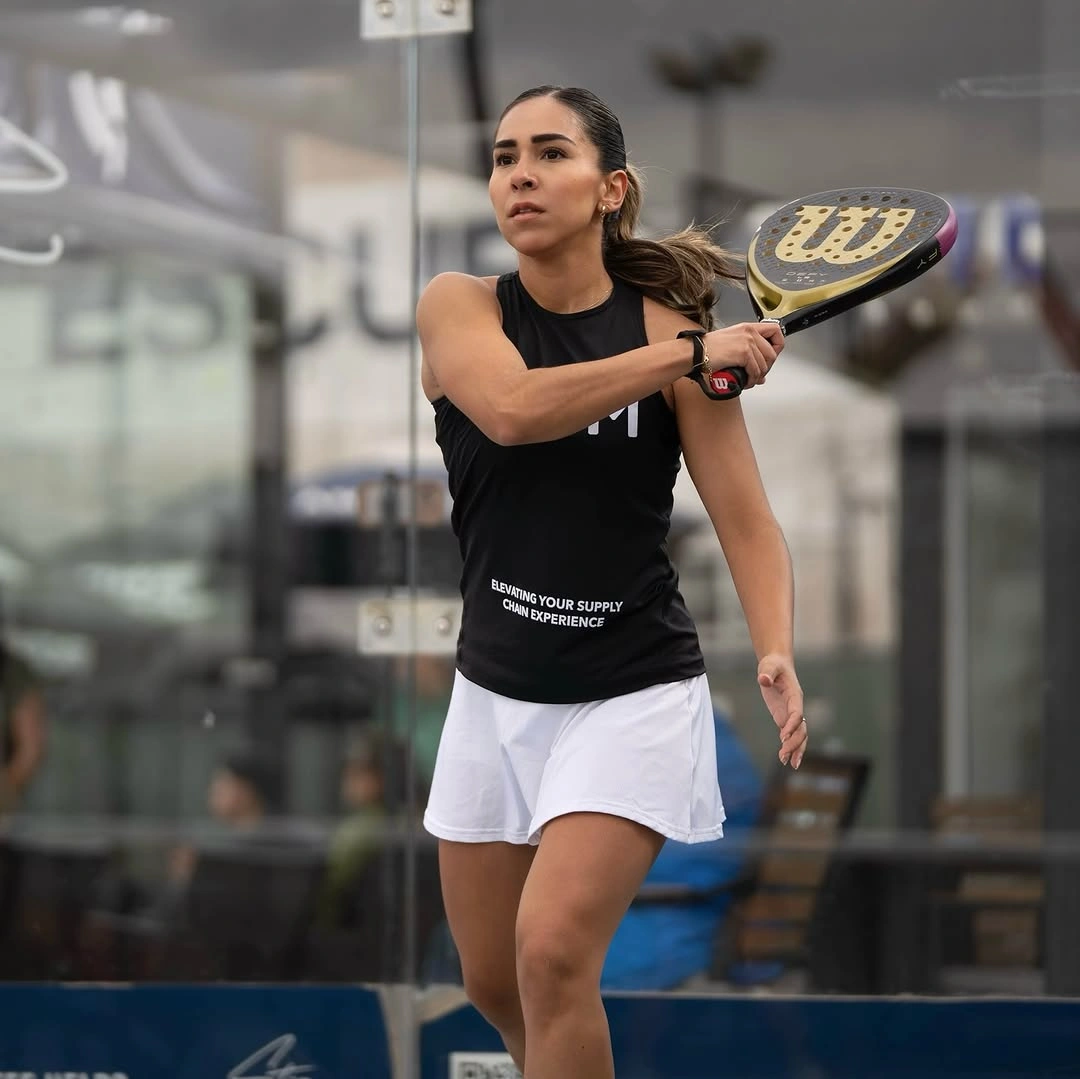 Black athletic T-shirt with white skort on an indoor court