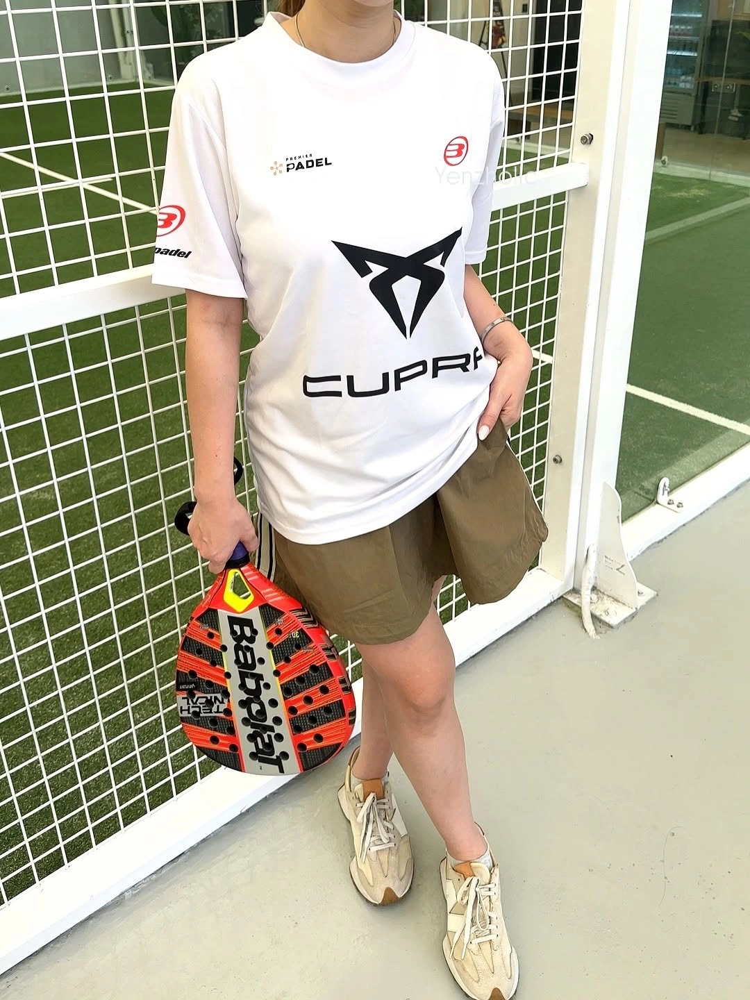 Oversized white T-shirt with olive shorts and neutral trainers