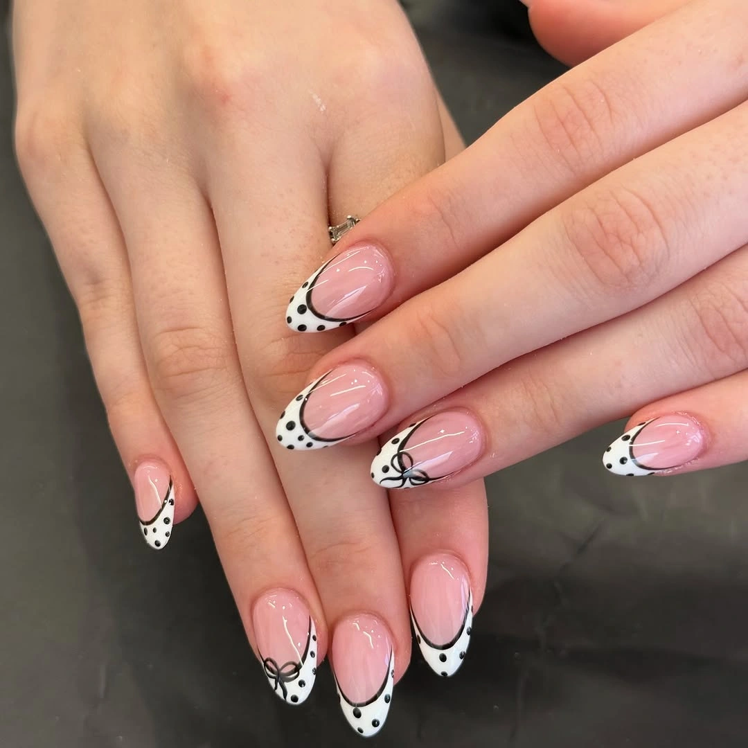 Pink nude almond nails with white dotted French arcs and fine black linework