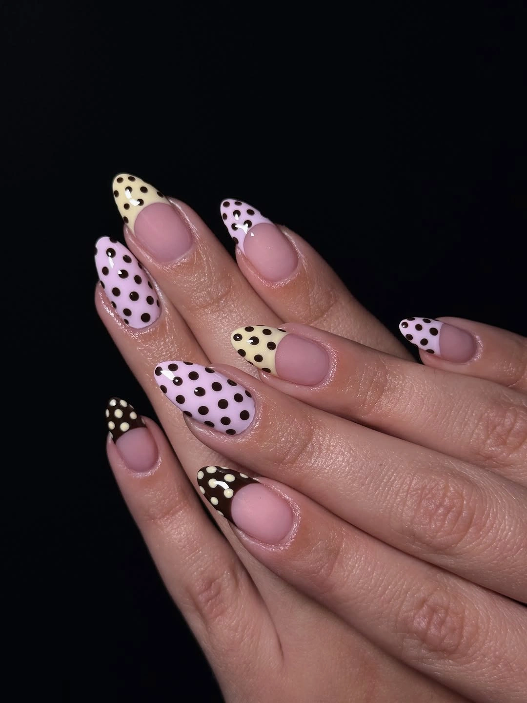 Dusty pink almond nails with black dots and pastel French-style accents