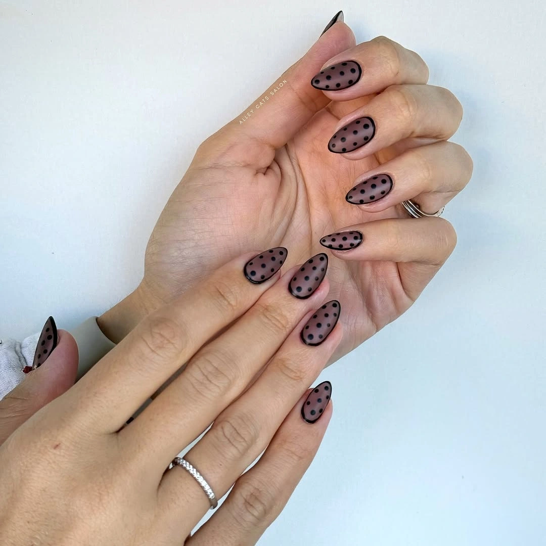 Muted mauve-brown almond nails with black dotted outline details