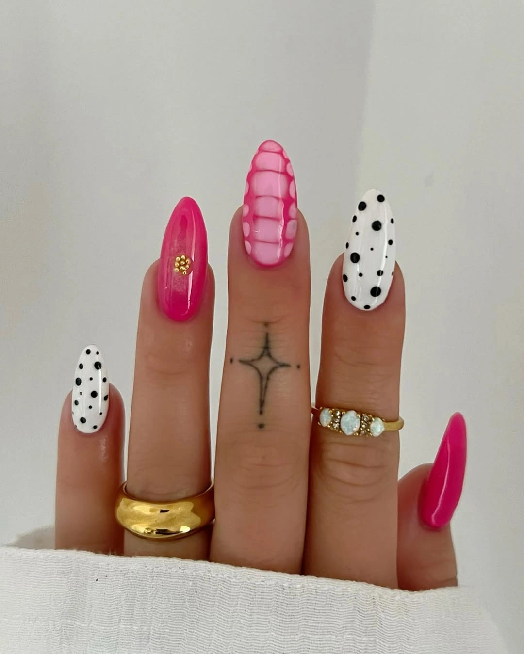 Long pointed hot pink nails with white black-dot accents and raised-looking line detail