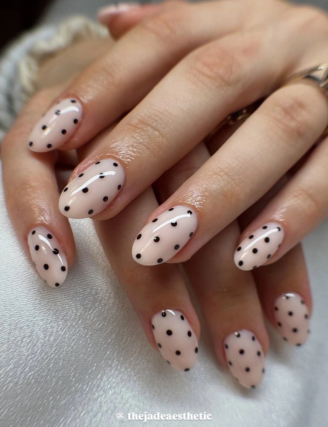 Medium rounded white nails with simple evenly spaced black polka dots