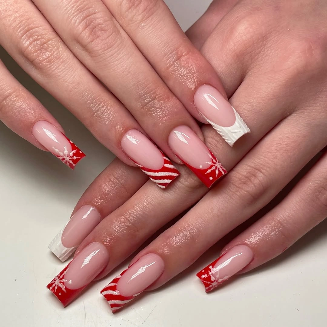 Long square pink nails with red white tips and snowflakes