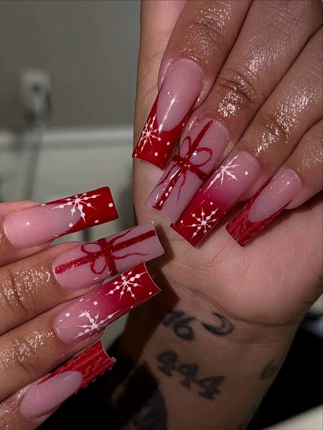 Extra long square pink nails with red bows and snowflakes