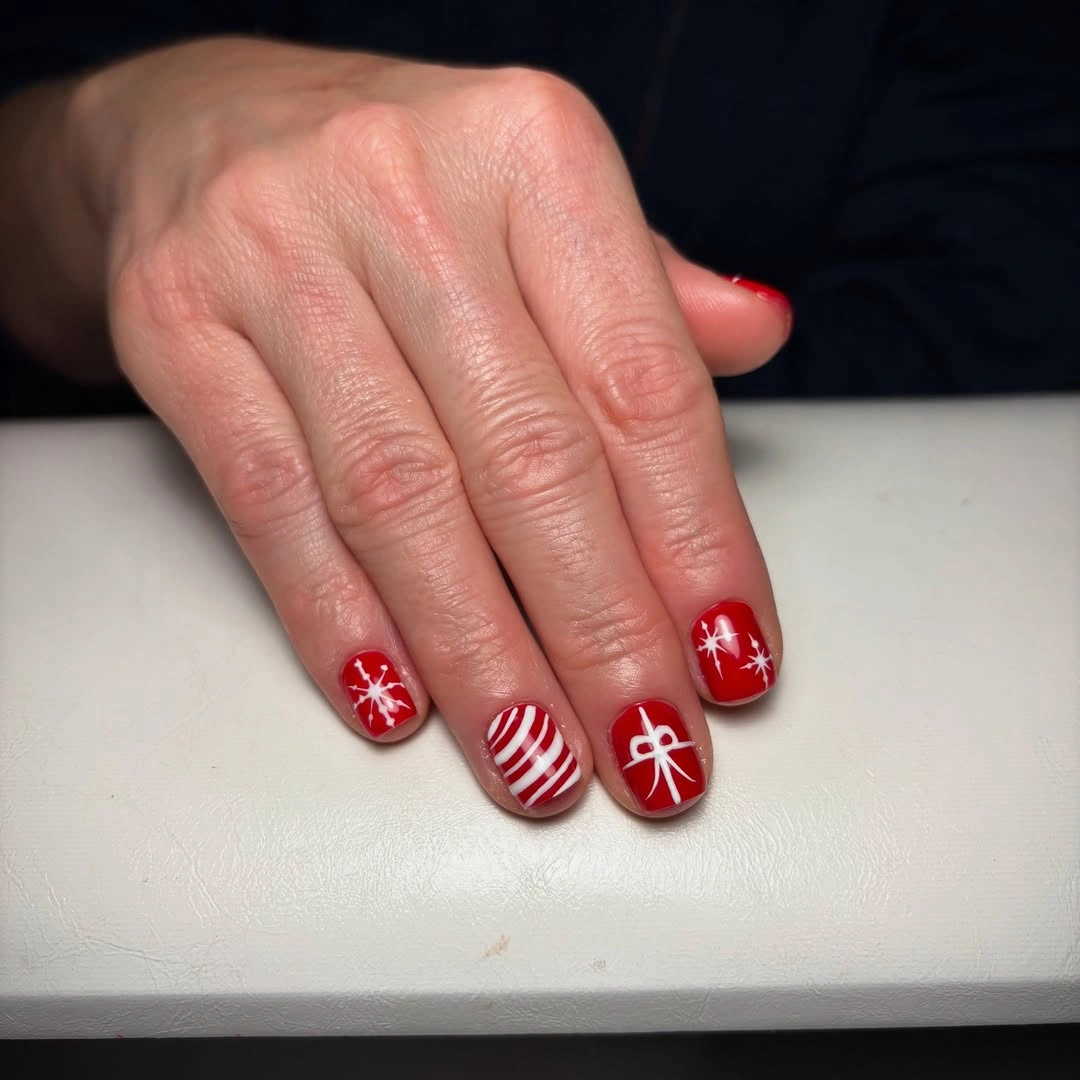 Short red square nails with snowflakes stripes and white bow