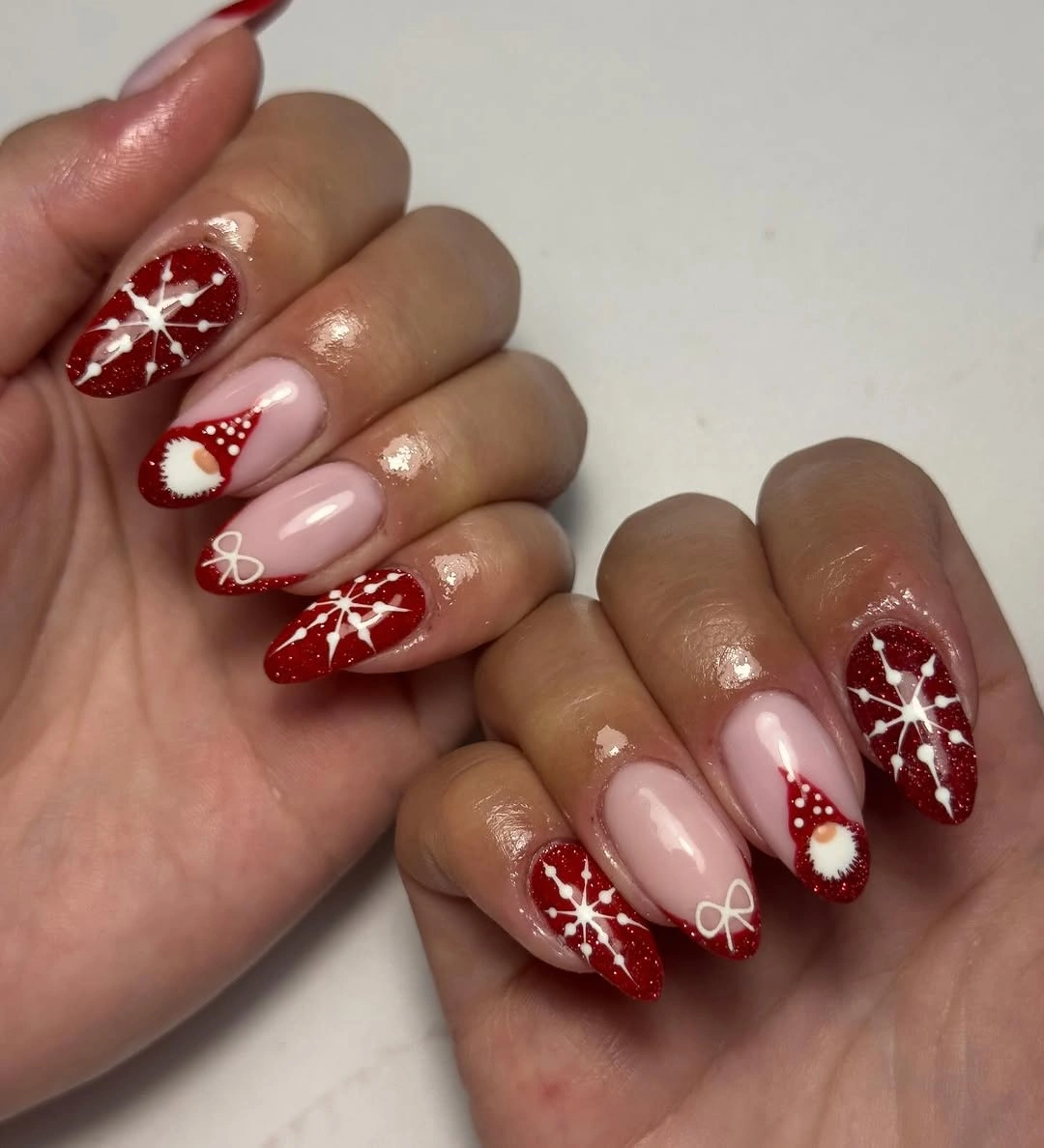 Almond red and pink nails with snowflakes bows and hat details