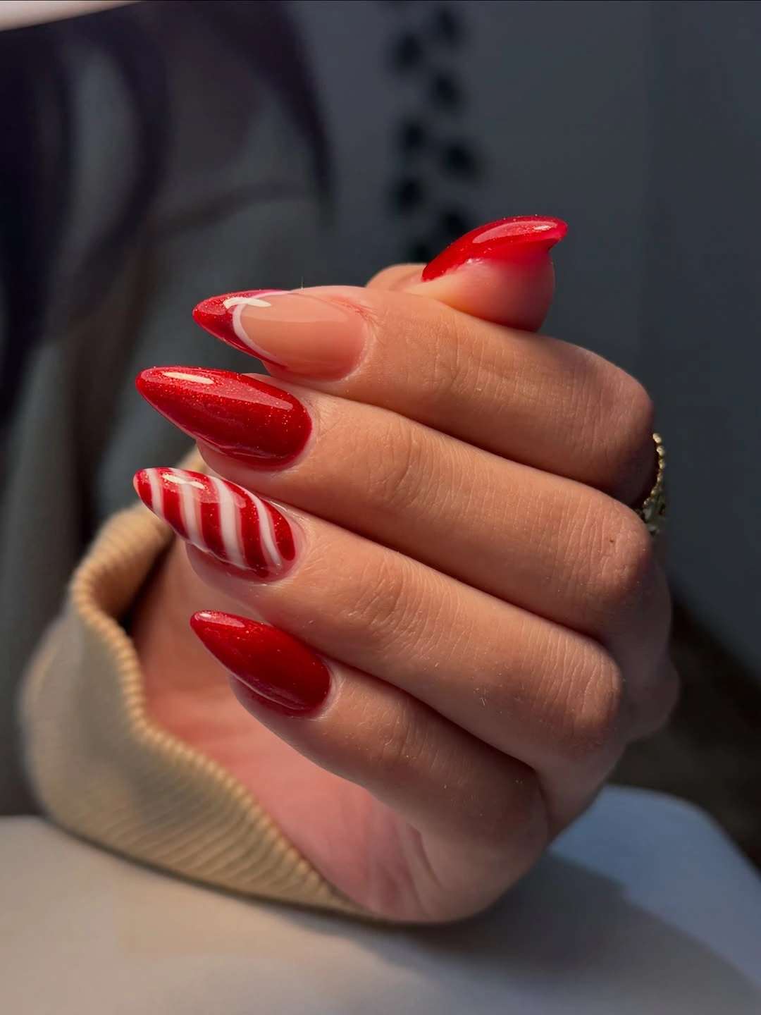 Almond red nails with candy stripes and curved pink accent