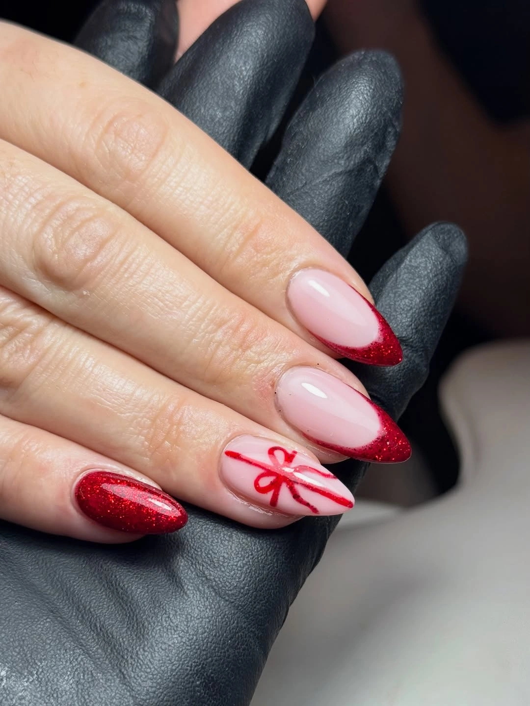Medium almond pink nails with sparkling red tips and bow