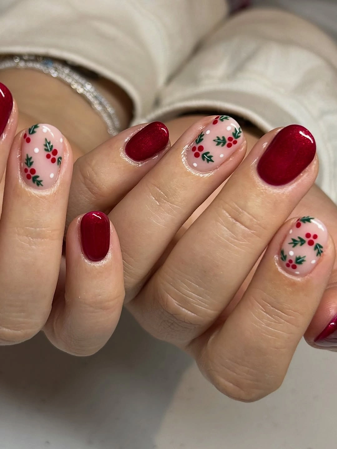 Short rounded deep red nails with small berry and leaf accents