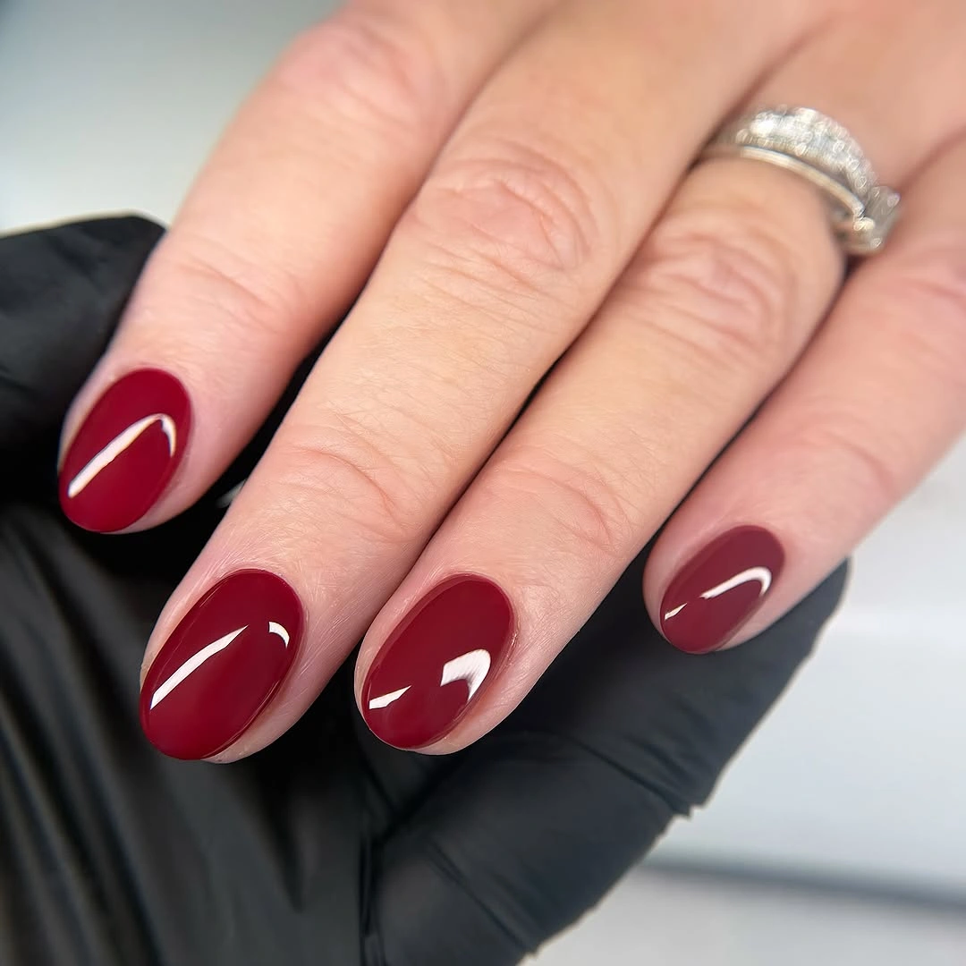 Short oval nails in glossy deep wine red