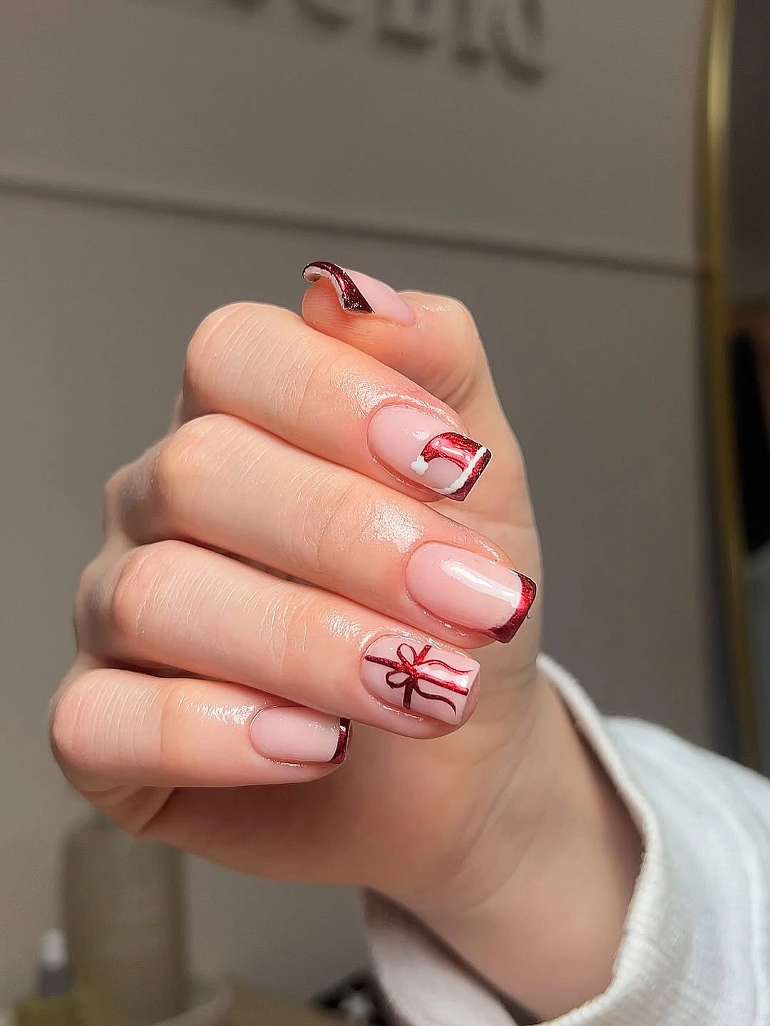 Short pale pink square nails with red tips and bow detail
