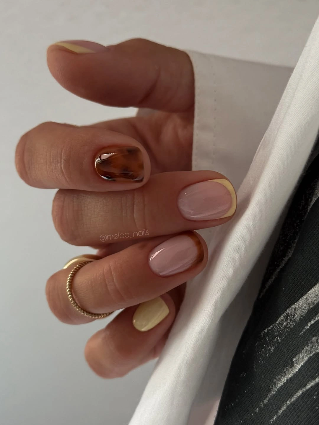 Nude short nails with yellow tips and tortoise-like accent