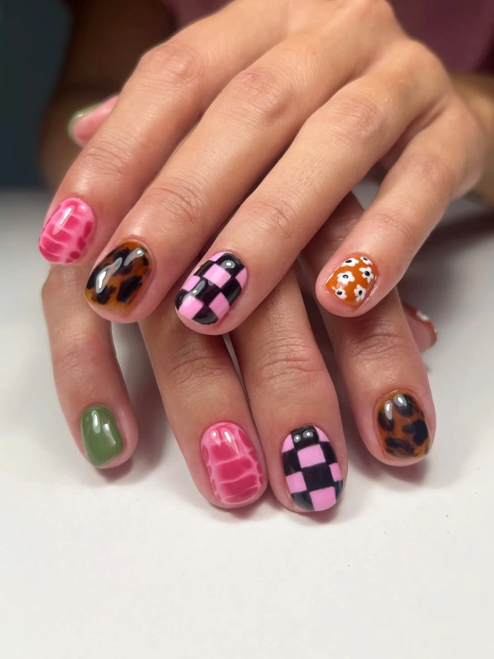 Short nails with checkerboard tortoise-like and floral patterns