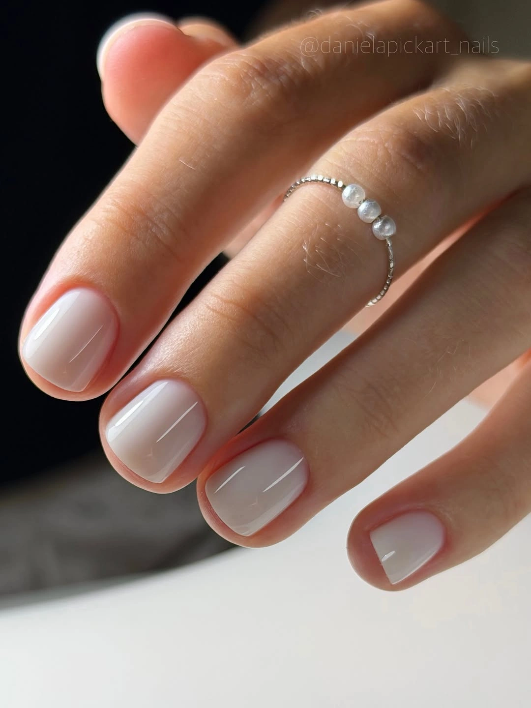 Very short rounded nails with sheer milky white gloss