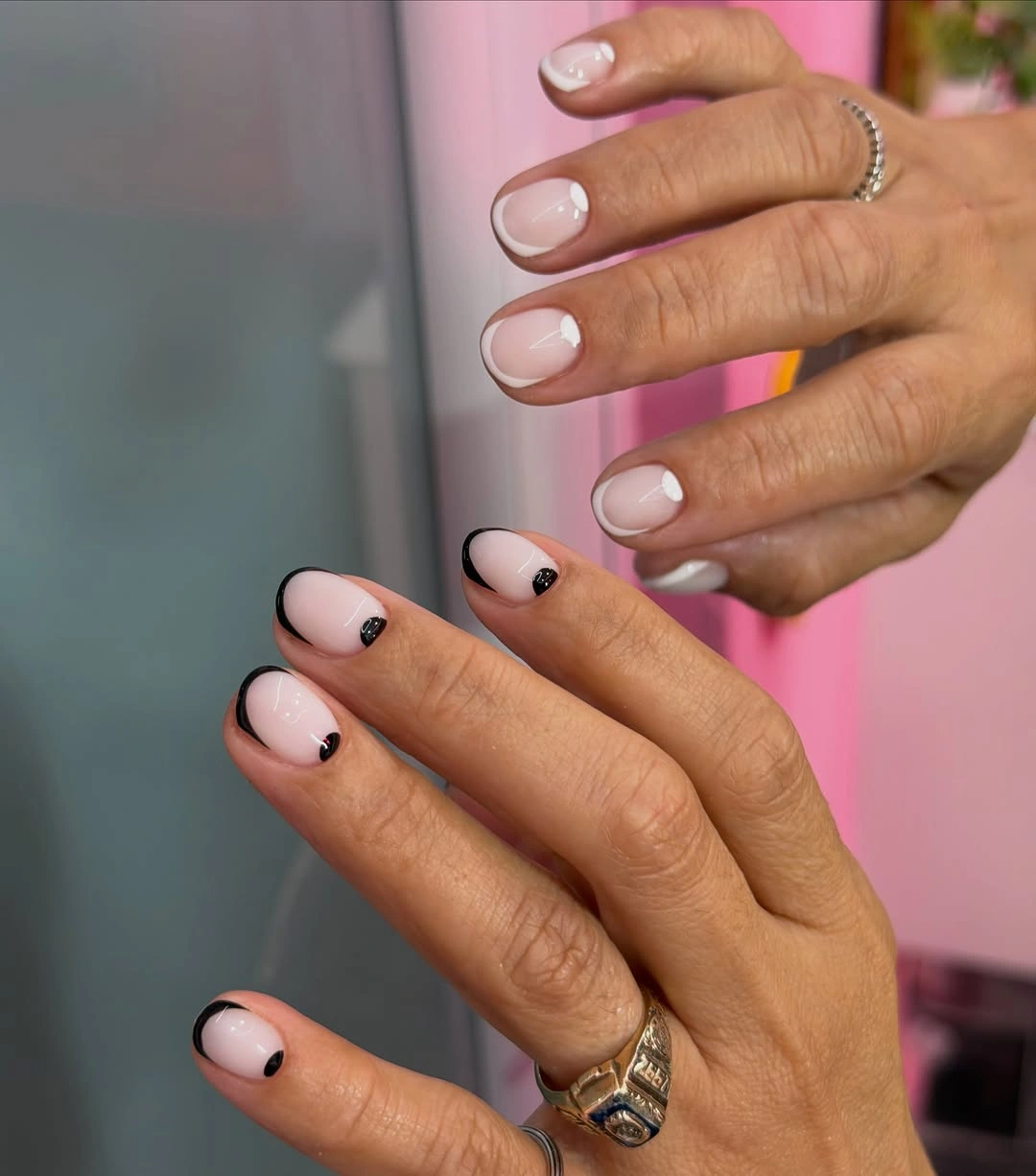 Nude pink short nails with black curved tips and dots