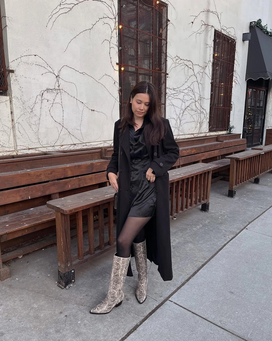 Black mini dress and long coat with reflective silver knee-high boots