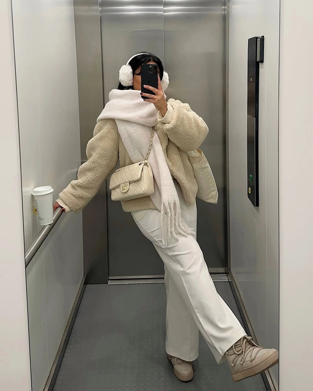 Cream fuzzy jacket with oversized scarf, wide trousers, and beige boots