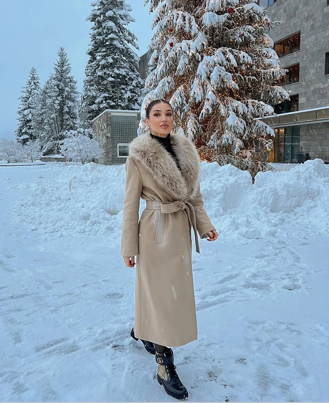 Beige belted long coat with fur-like collar and black boots