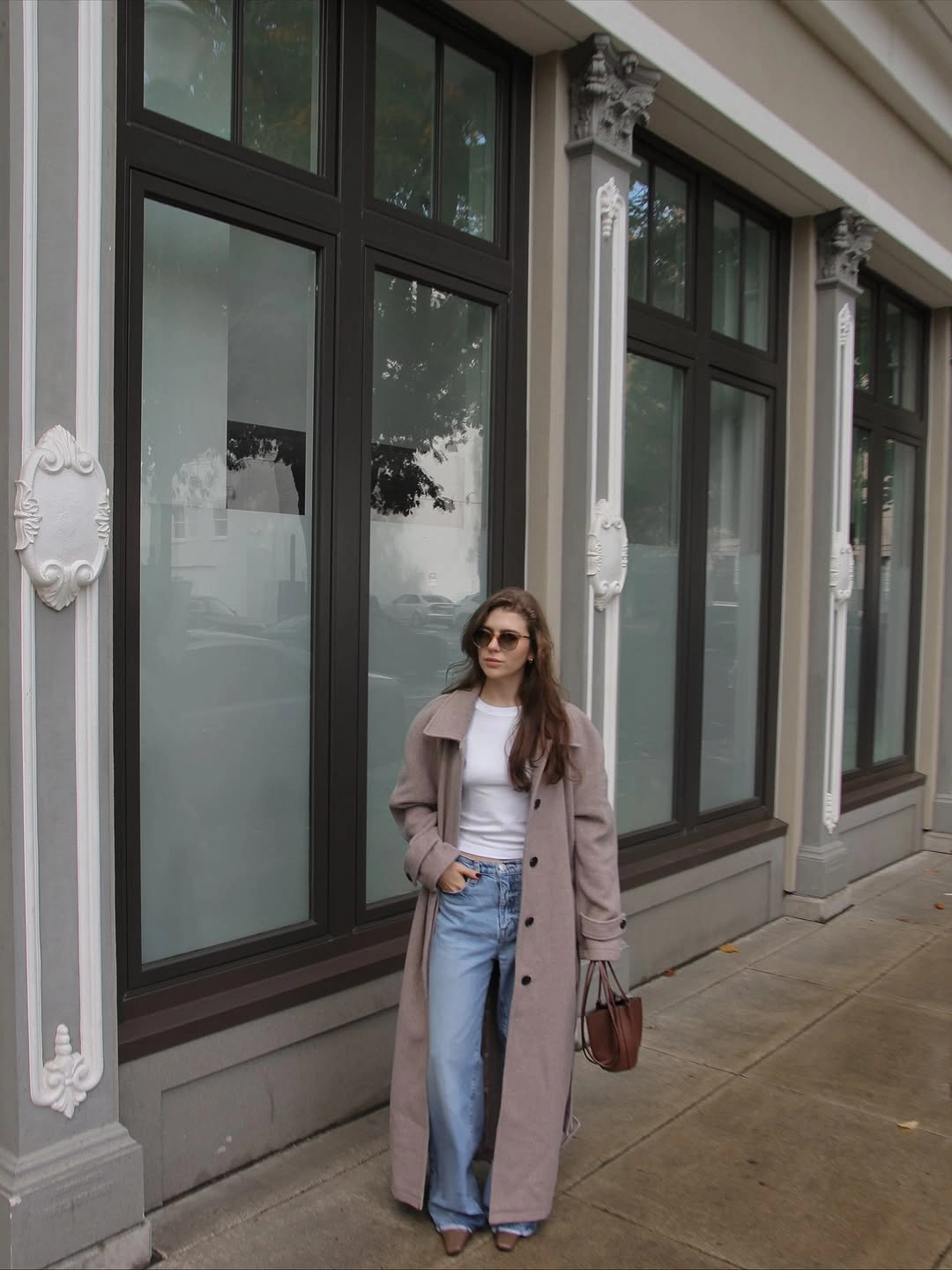 Mauve long coat with white top, light jeans, handbag