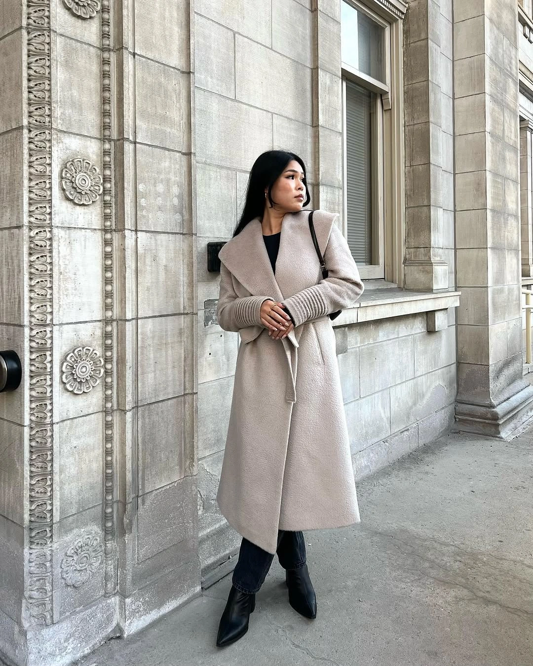 Light beige belted coat with black trousers and pointed boots