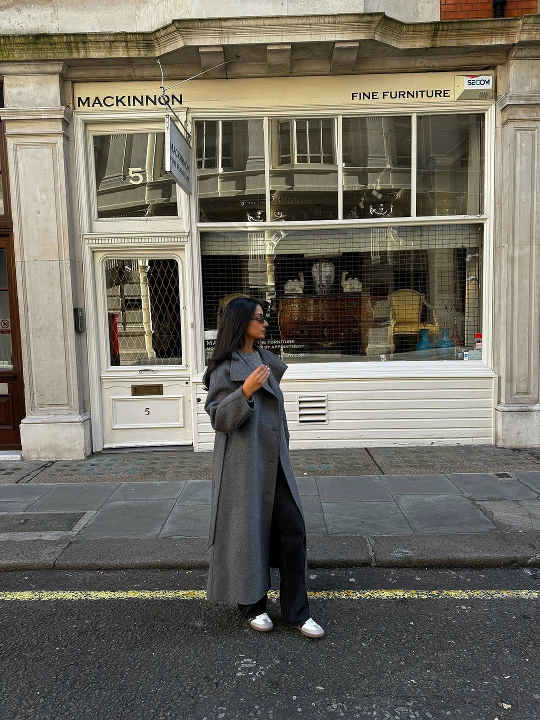 Long gray coat with black outfit and light flat shoes