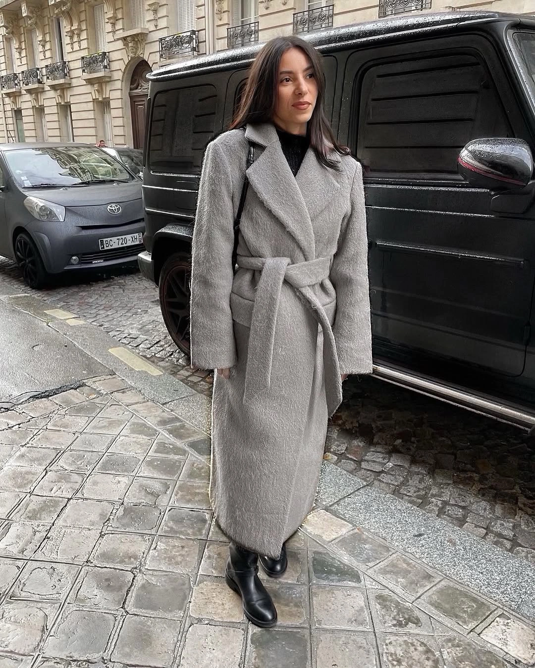 Gray belted long coat with black top and black boots