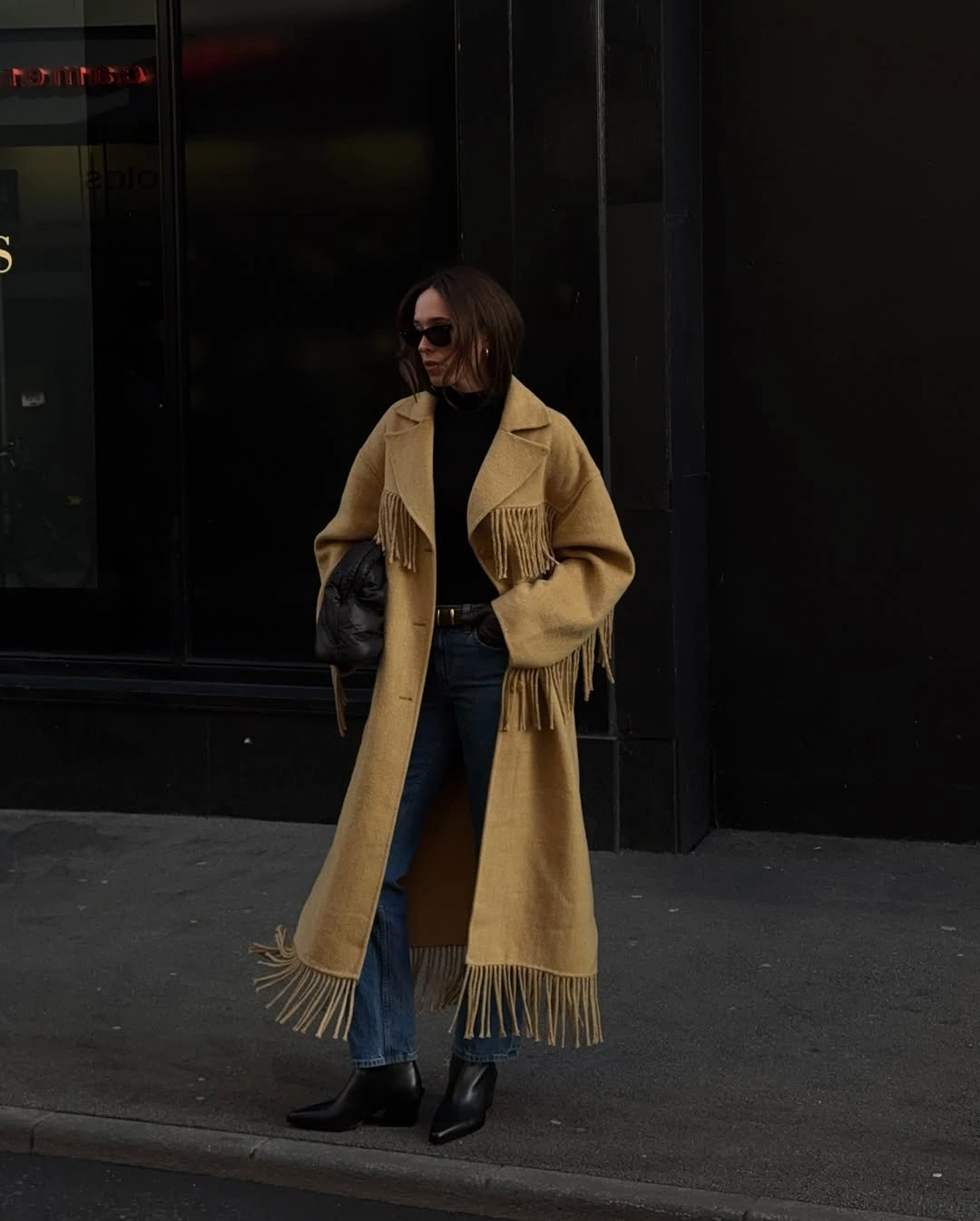 Camel long coat with fringe, jeans, black boots, handbag