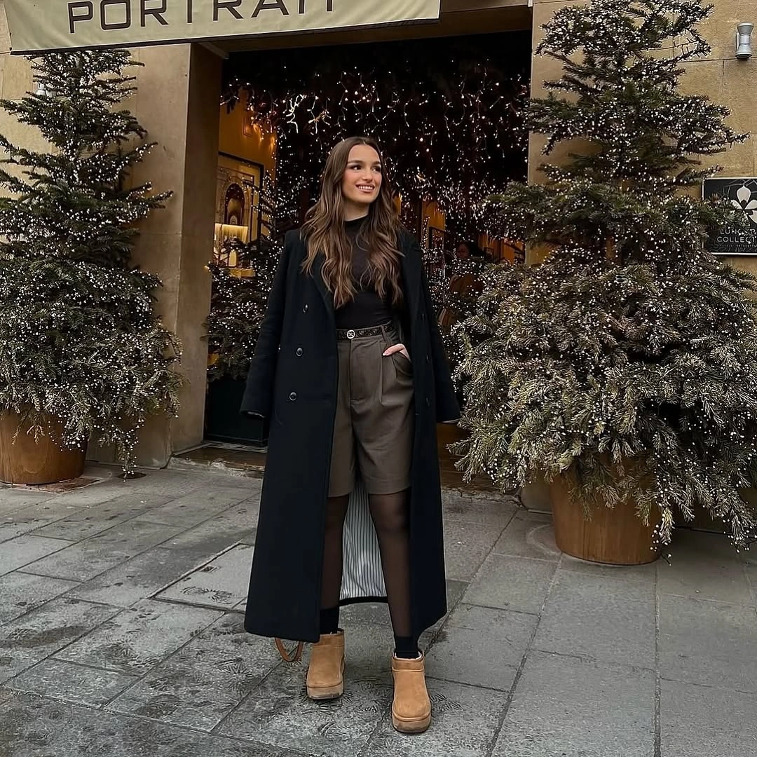Long black coat with taupe lower layer and tan ankle boots