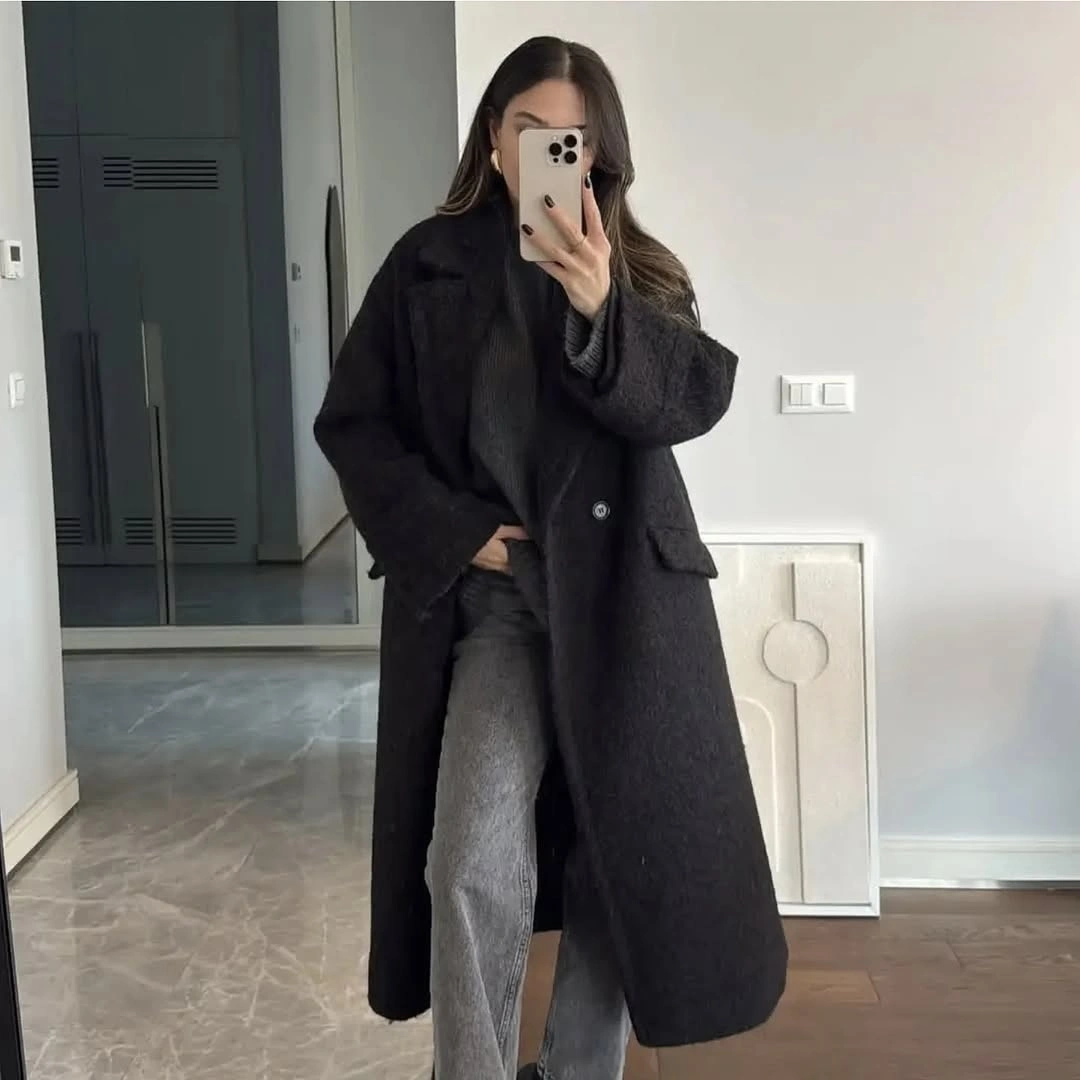 Black long coat with gray jeans in mirror selfie