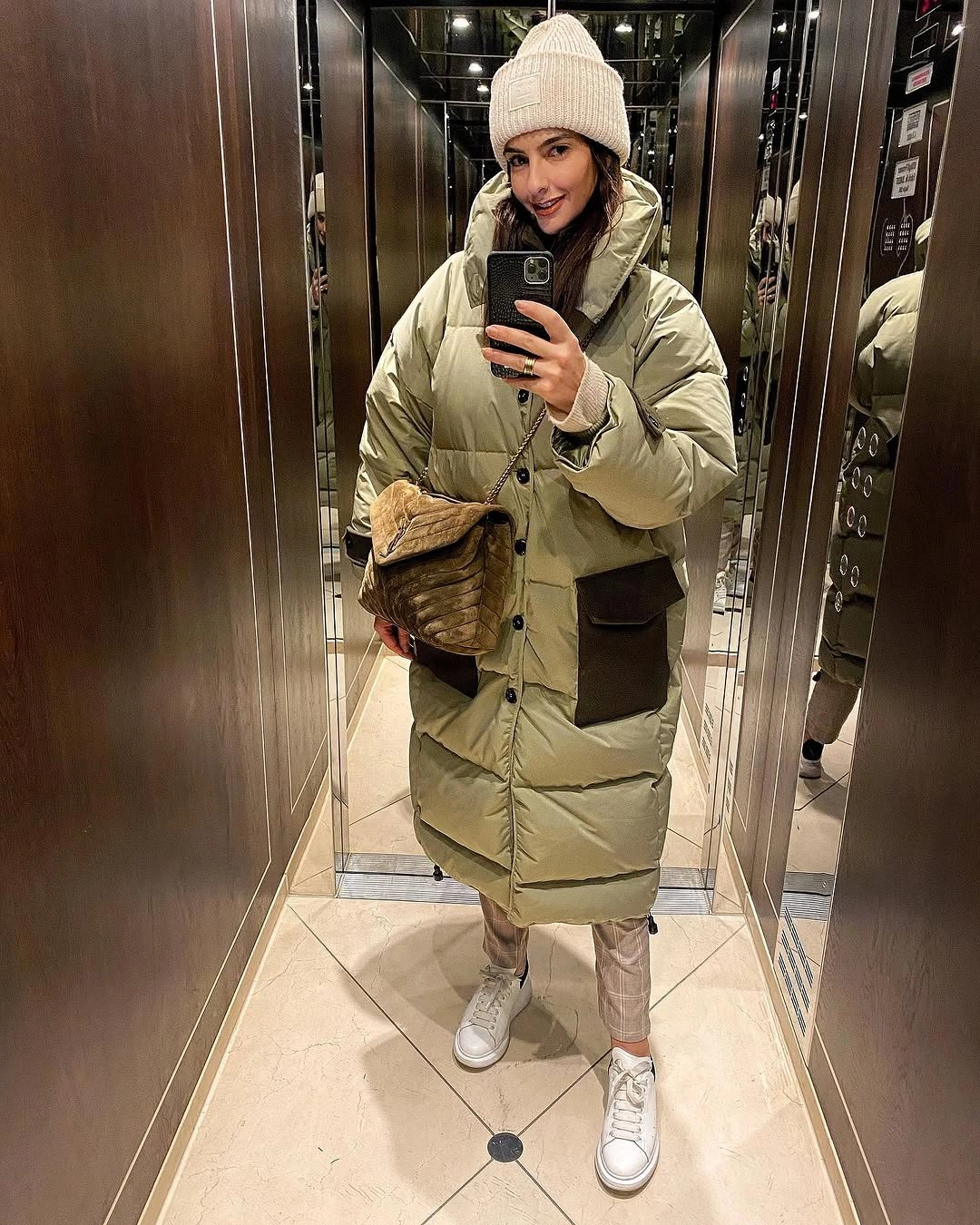 Olive long puffer with black pockets and white sneakers