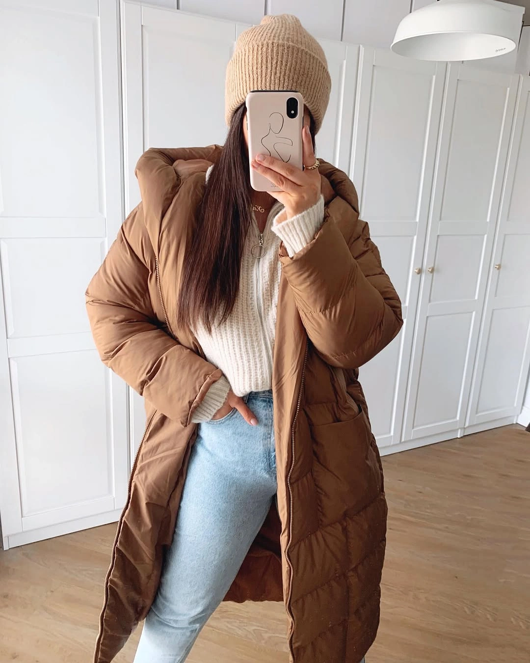 Camel long puffer with beige beanie and light jeans