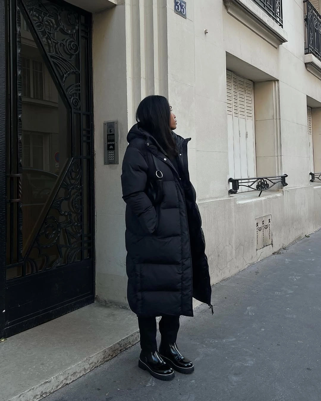 Long black puffer with black outfit and shiny shoes