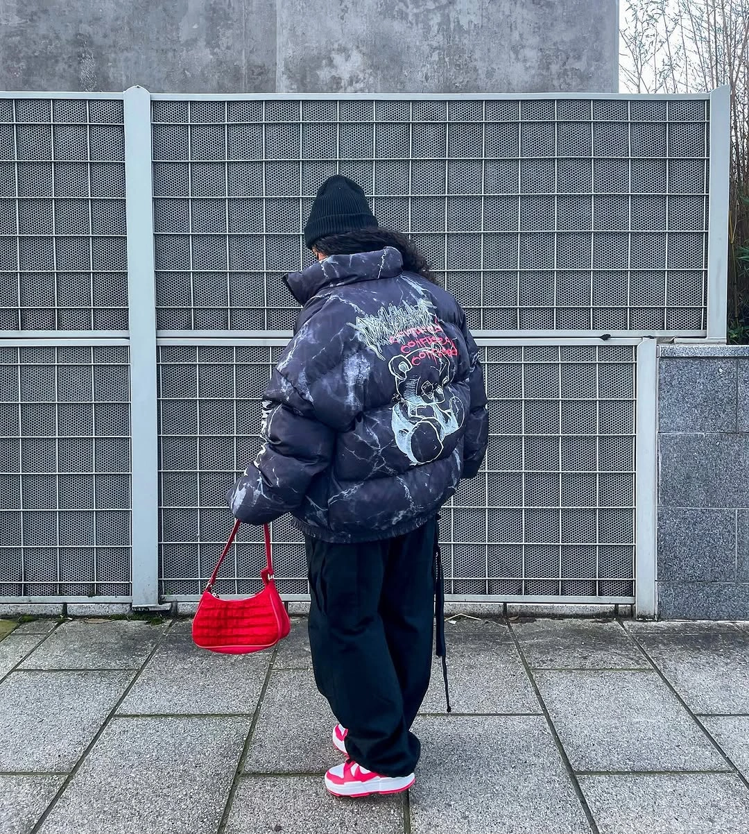 Navy puffer back view with red bag and red sneakers