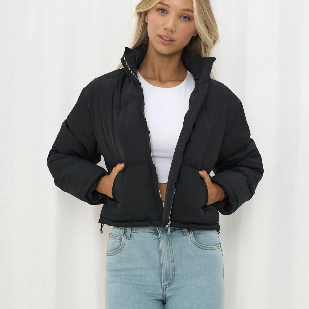 Black short puffer over white top and light jeans