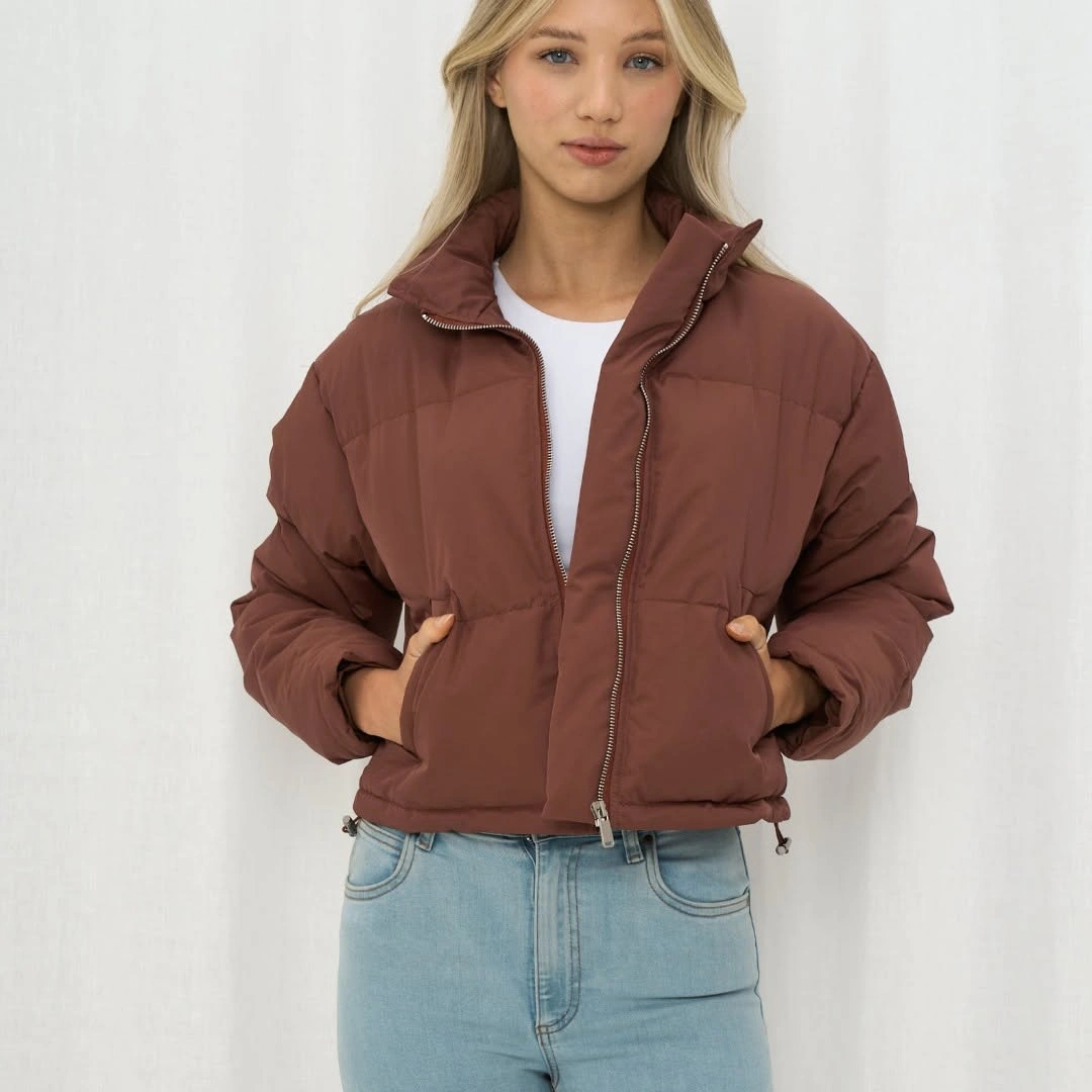 Brown short puffer over white top and light blue jeans