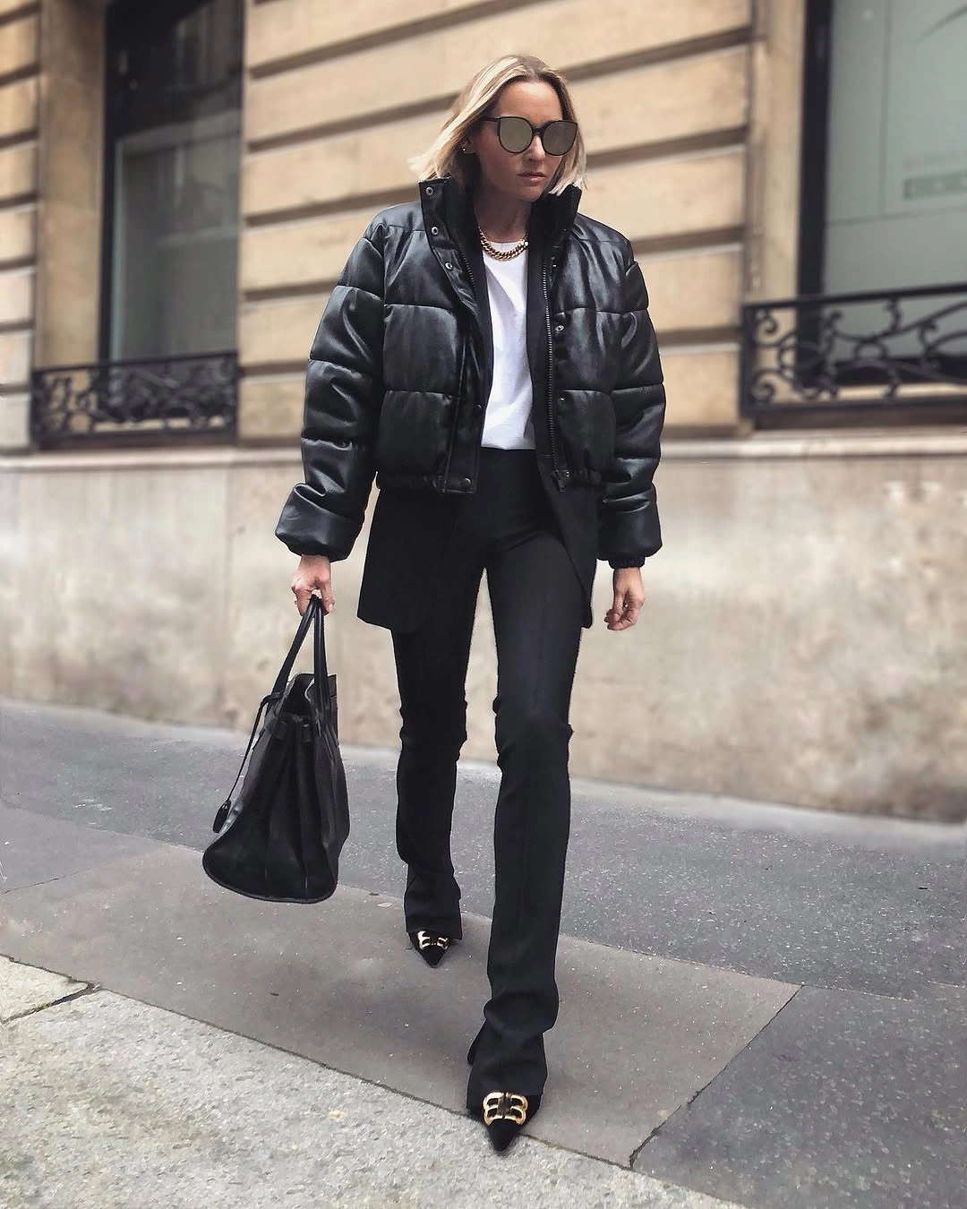 Black shiny short puffer with white top and black handbag