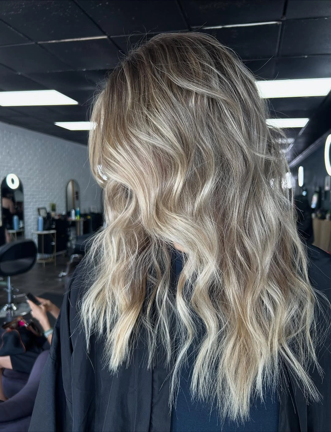 Rear view of medium-long blonde wavy layered hair